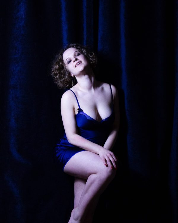 Marie Surget devant un rideau en velours bleu.